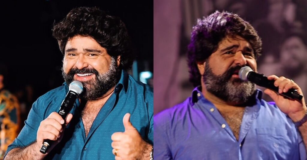 Fabiano Menotti desabafa após acidente de carro: ‘Livramento’ Montagem com duas imagens do cantor sertanejo Fabiano Menotti, um homem adulto de pele clara, cabelos escuros volumosos e barba cheia, segurando um microfone. Em uma das fotos, ele sorri e faz gesto positivo com a mão, vestindo camisa azul escura. Na outra, aparece cantando com expressão emocionada, usando camisa azul clara sob iluminação de palco. Ambos os registros mostram apresentações musicais ao vivo, com fundo escuro e luzes de show desfocadas.
