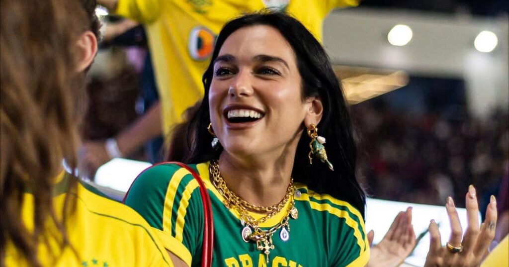 Dua lipa sorrindo sando a blusa fo brasil