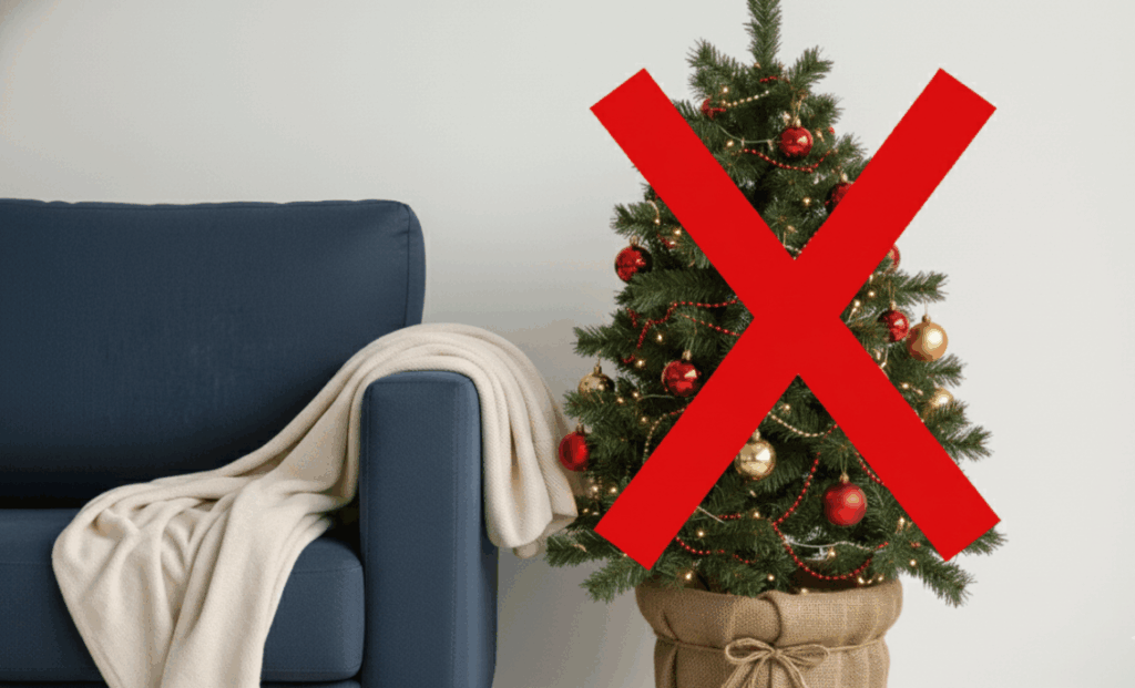 Adeus, árvore de Natal: a planta vermelha que promete dominar 2025 Árvore de Natal decorada ao lado de um sofá, marcada com um grande X vermelho para ilustrar cuidados e restrições relacionados à Tuia Holandesa vermelha.