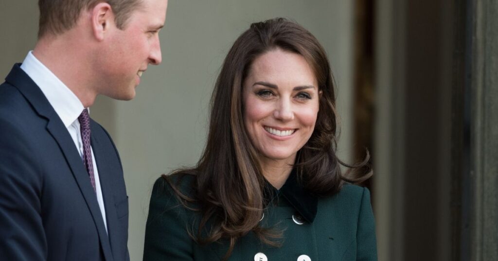 Kate Middleton sorri enquanto conversa com o príncipe William durante evento oficial.