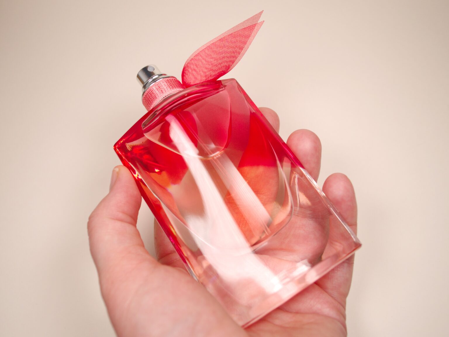 4 perfumes mais baratos e idênticos ao La Vie Est Belle para usar nas festas de fim de ano pessoa segurando frasco do perfume La Vie Est Belle