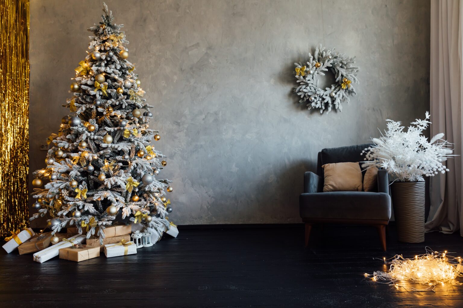 O melhor lugar da casa para colocar a árvore de Natal e atrair boas energias, segundo o Feng Shui Sala decorada com árvore de Natal nevada e enfeites dourados mostrando o melhor lugar para colocar a árvore de Natal segundo o Feng Shui.