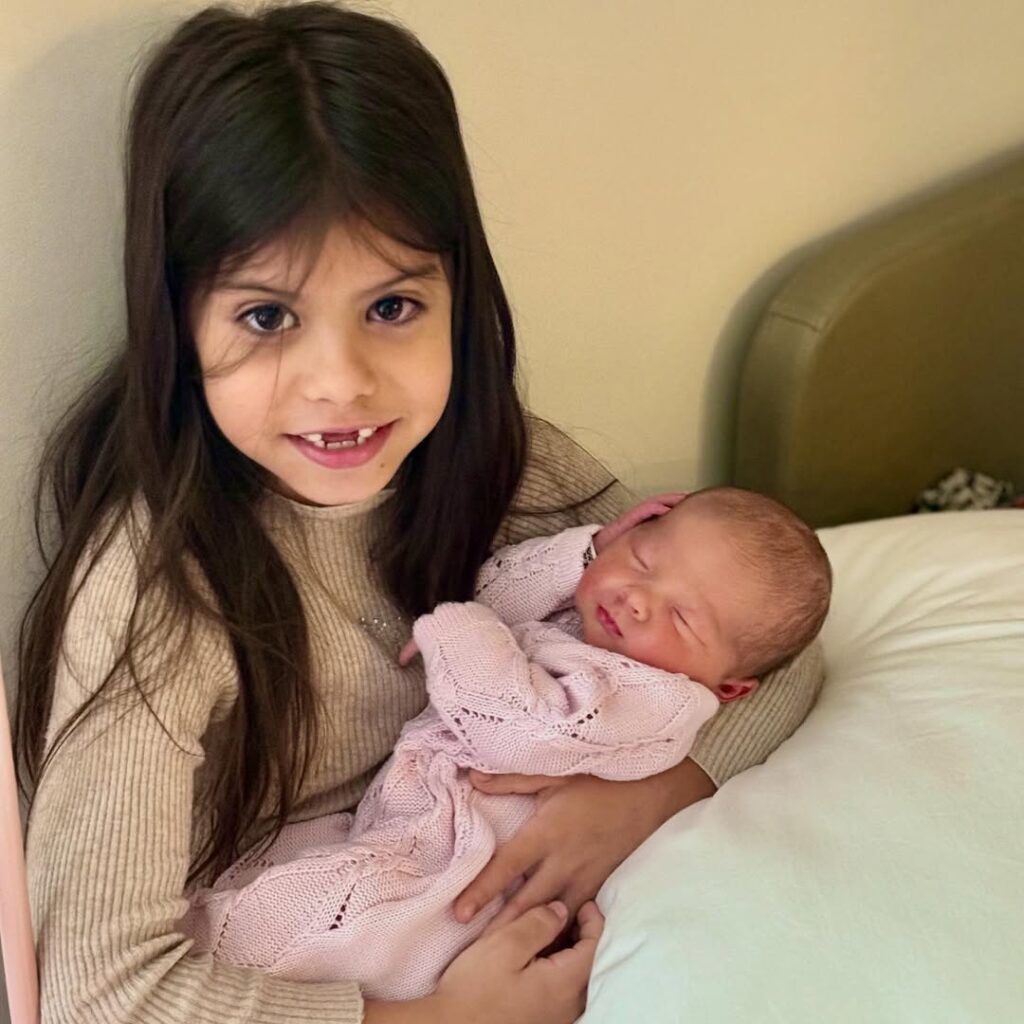 Chegadas que emocionaram: relembre os bebês de famosos que nasceram em 2025 4 Filha de Maíra Cardi segura a irmã recém-nascida no colo em registro feito no hospital, logo após o nascimento.