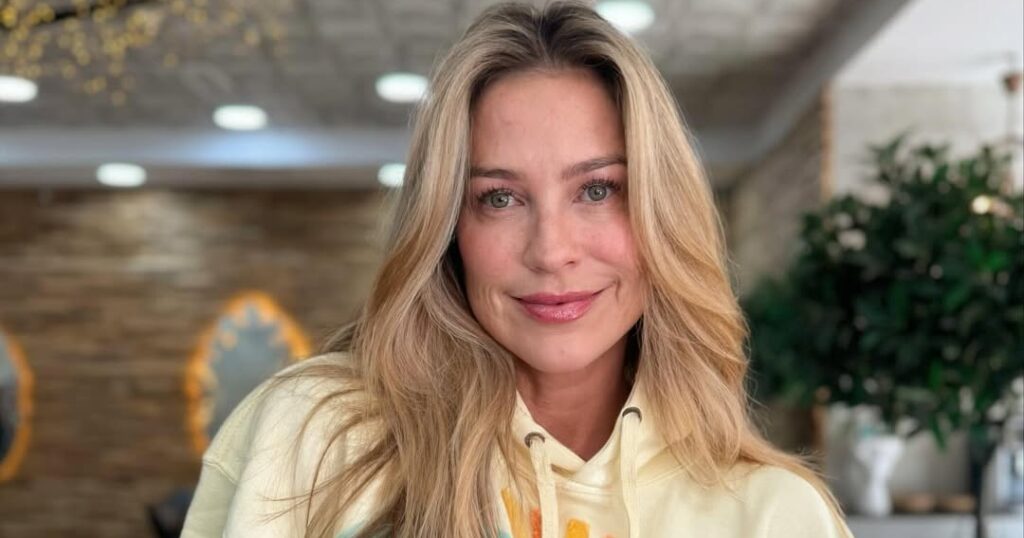 Luana Piovani posa sorridente em ambiente interno usando moletom claro com estampa colorida