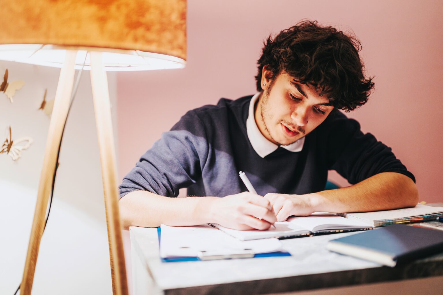 Jovem estudando e escrevendo em um caderno, representando a prática de dicção com palavras em português difíceis de pronunciar