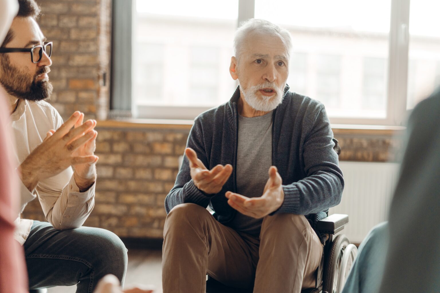 Homem idoso conversando em grupo terapêutico, representando atenção à saúde mental na meia-idade e prevenção da demência