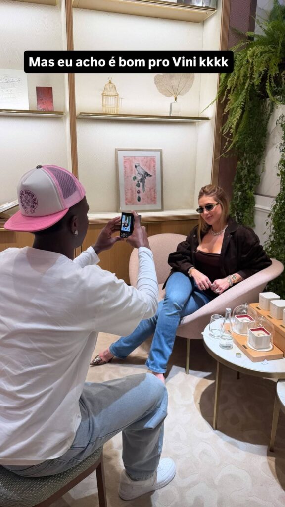 Vini Jr. tira fotos de Virginia Fonseca sentada em poltrona dentro de loja de luxo em Madri durante passeio do casal
