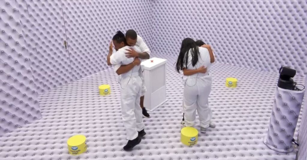 Quarto Branco BBB 26: prova extrema termina com quatro novos brothers na casa Participantes do BBB 26 se abraçam emocionados dentro do Confessionário durante dinâmica especial, em ambiente acolchoado branco, momentos antes de decisão no jogo