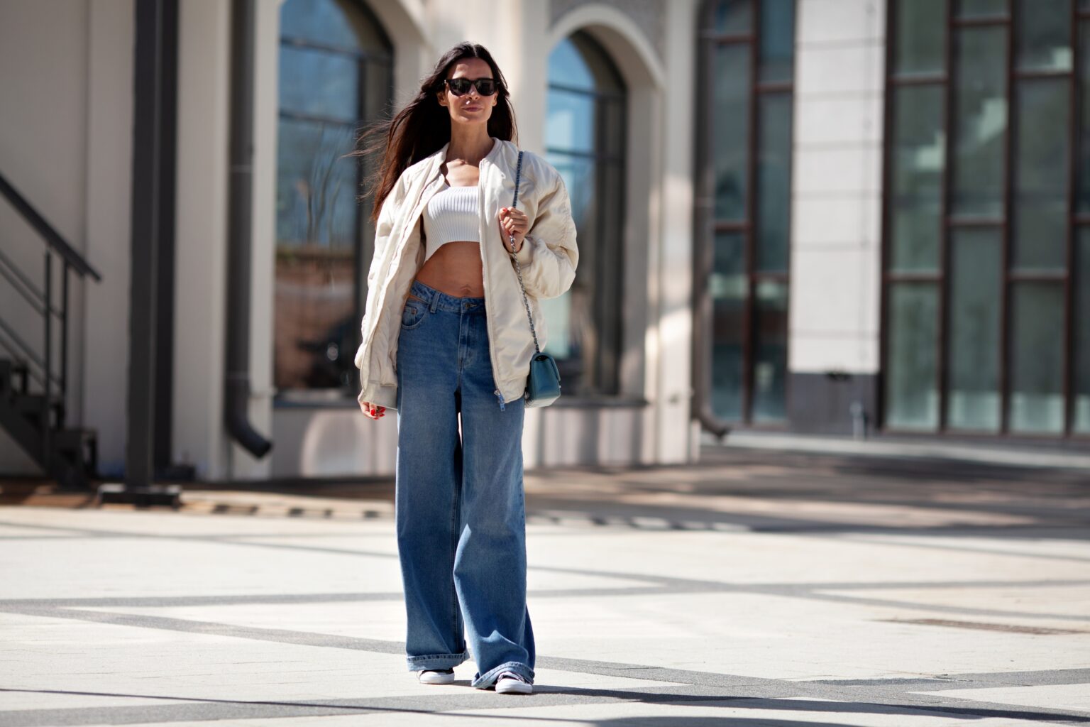 Mulher usando calça jeans de lavagem média em look urbano, exemplo de como combinar a lavagem do jeans para um visual equilibrado e moderno