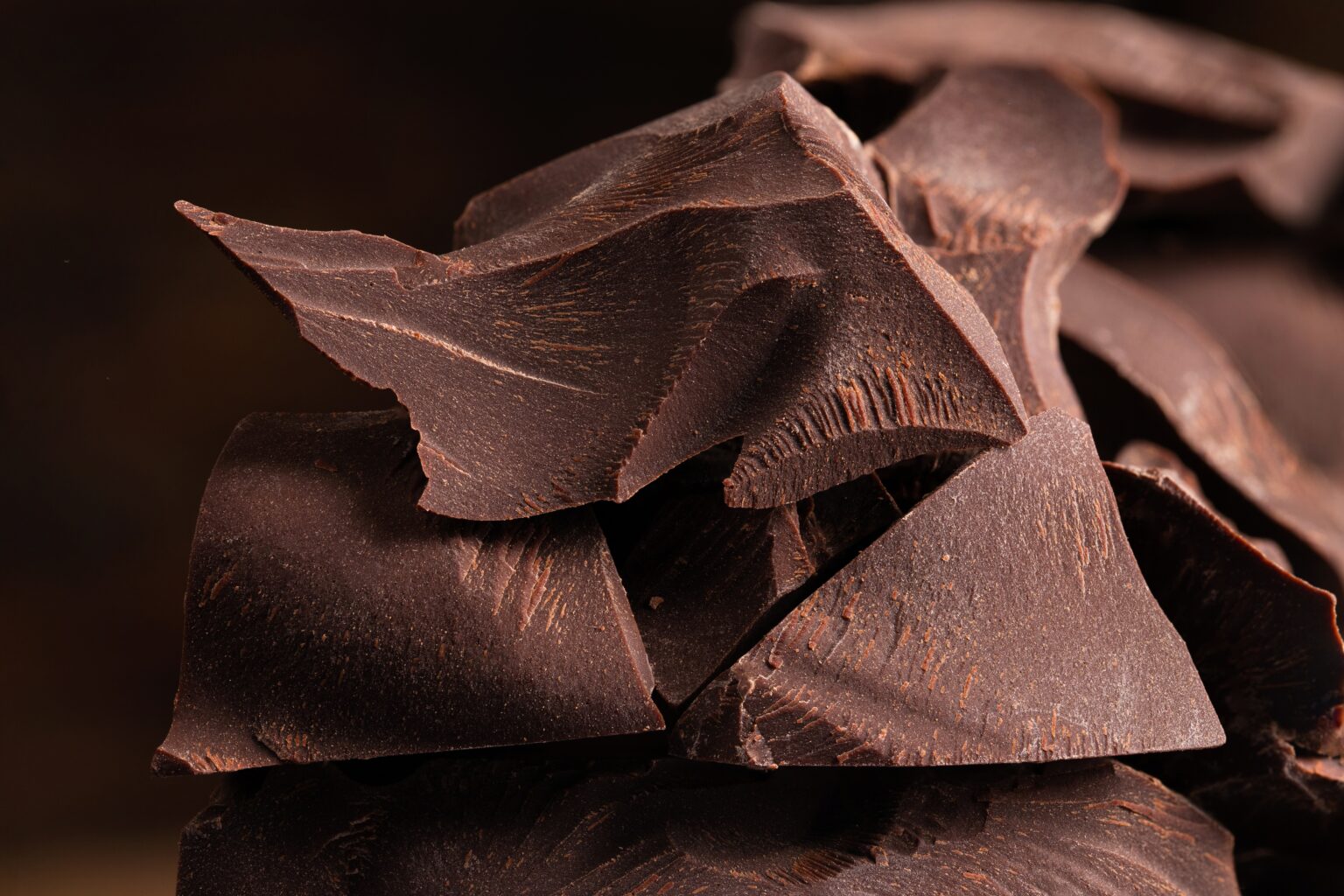 Pedaços de chocolate amargo com alto teor de cacau, fonte de teobromina associada a possíveis efeitos no envelhecimento biológico