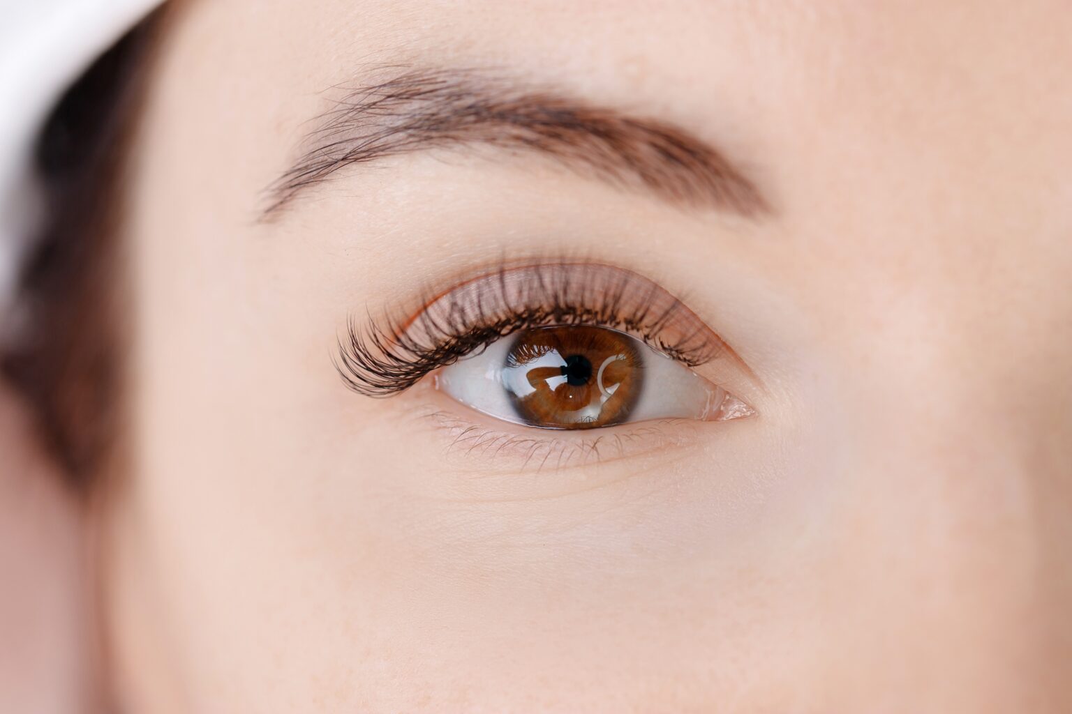 Como alongar e dar mais volume aos cílios com 4 truques simples e acessíveis Close no olho feminino com cílios longos, curvados e volumosos, destacando técnicas simples para alongar os cílios e realçar o olhar.
