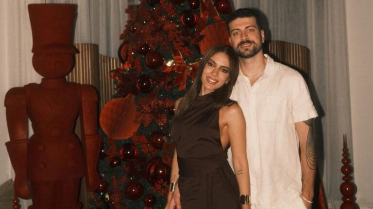 Anitta e Ian Bortolanza posam juntos em evento com decoração natalina ao fundo