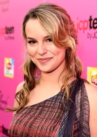 Bridgit Mendler sorrindo no tapete vermelho com vestido estampado, imagem que representa uma das celebridades que sumiram das séries da Disney para seguir novos caminhos fora da televisão.