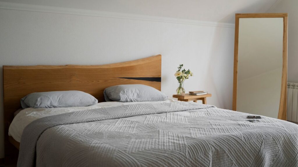Foto de um quarto iluminado com uma cama de madeira para ilustrar tendência de 2026