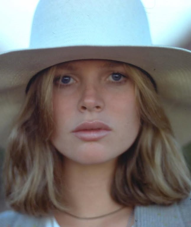 Famosos que perderam tudo: 10 celebridades que enfrentaram crises financeiras e deram a volta por cima 10 Kim Basinger com chapéu claro e expressão séria representando famosos que perderam tudo