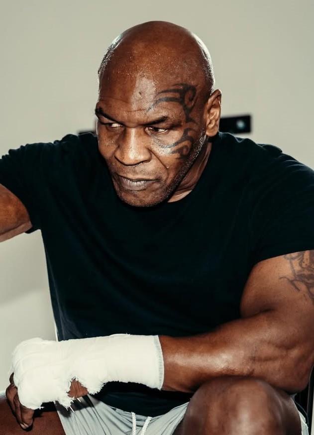 Famosos que perderam tudo: 10 celebridades que enfrentaram crises financeiras e deram a volta por cima 1 Mike Tyson com expressão séria e mão enfaixada representando famosos que perderam tudo