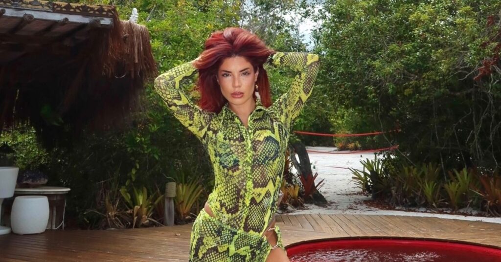Gkay posa com vestido verde estampado em área externa com vegetação durante ensaio para redes sociais