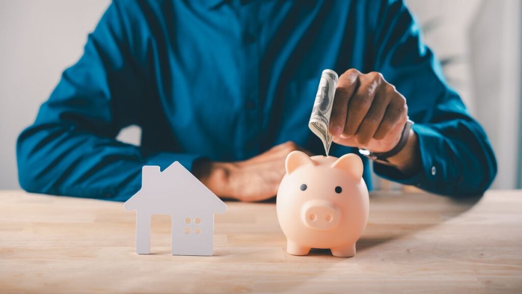 guardar dinheiro ganhando pouco com pessoa colocando nota em cofrinho representando economia e planejamento financeiro