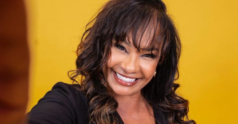 Solange Couto sorri em retrato oficial com fundo amarelo após participação no BBB 26