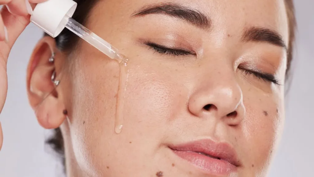 Retinol ou retinal: qual realmente faz mais diferença na sua pele? aplicação de sérum facial com conta-gotas na pele, rotina de skincare com retinol ou retinal para melhorar textura e sinais de envelhecimento