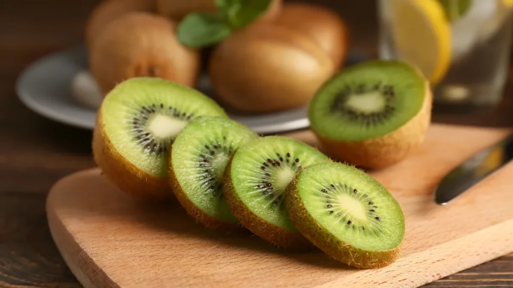 Kiwi cortado em fatias sobre tábua de madeira destacando nutrientes associados à saúde intestinal e cardiovascular