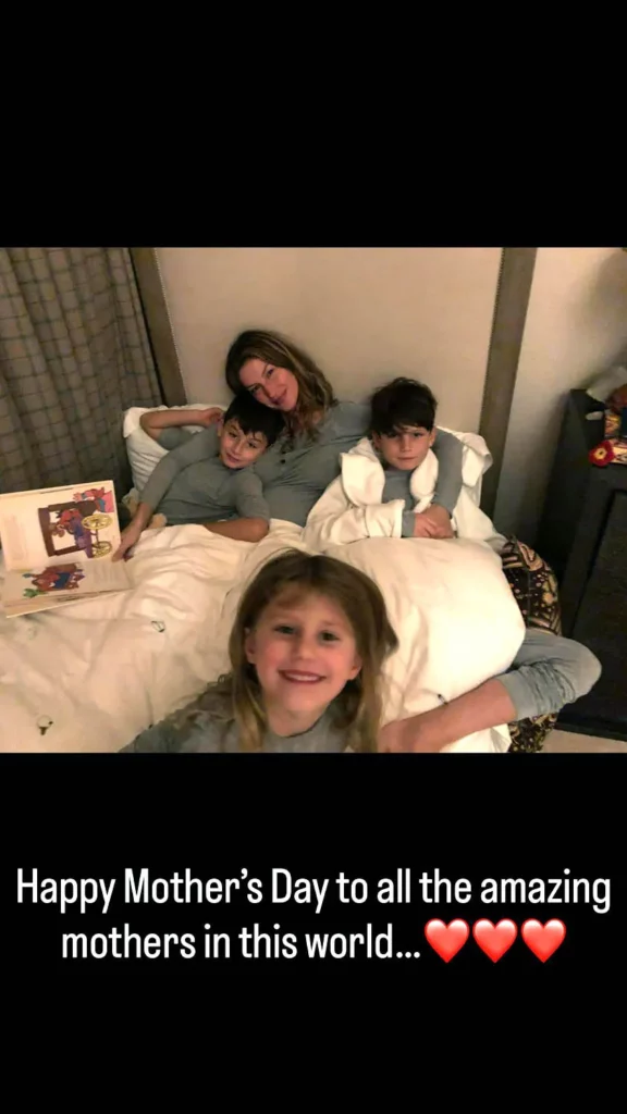 Gisele Bündchen e três crianças, filhos de Tom Brady, reunidos na cama em momento familiar, com mensagem de Dia das Mães na imagem.

