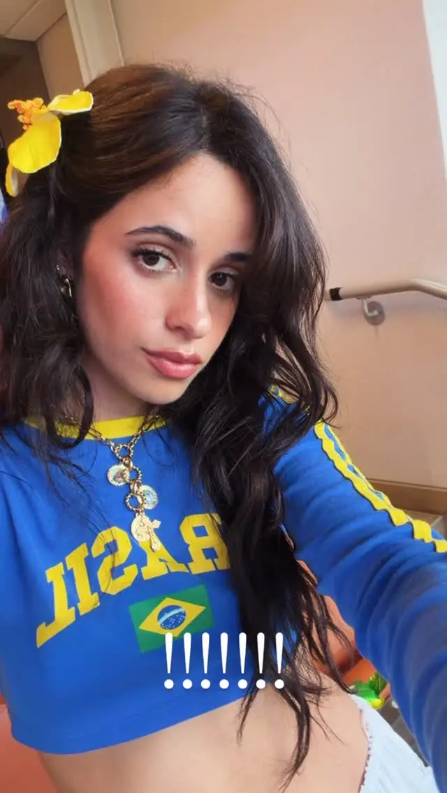 Camila Cabello faz selfie com camisa do Brasil e flor amarela no cabelo