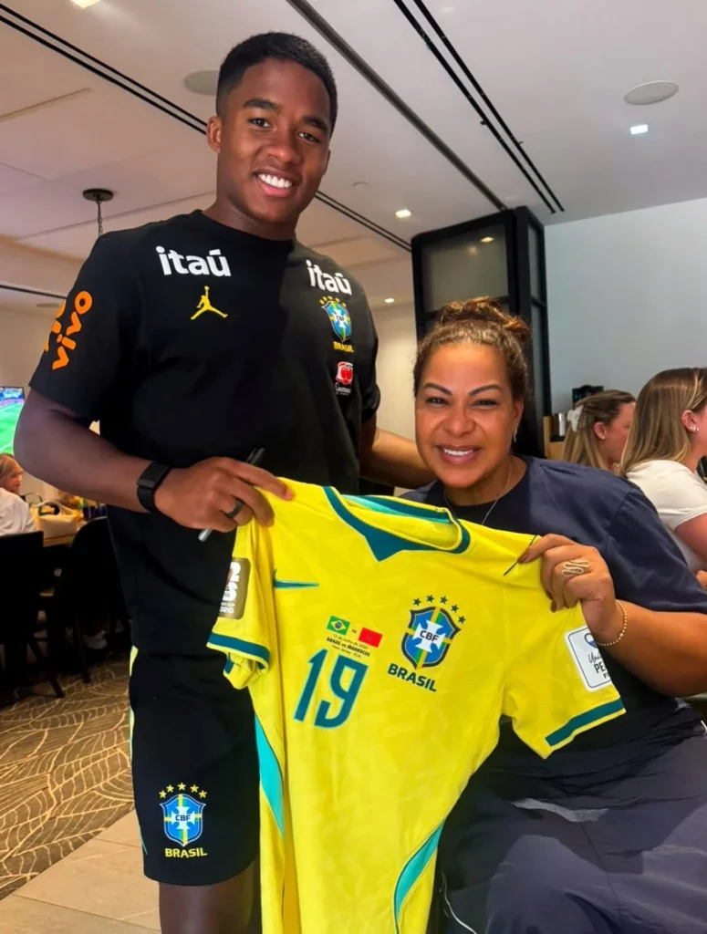 Mãe de Endrick reencontra o filho na Copa e posa com estrelas da Seleção; veja 1 Endrick posa ao lado da mãe, Cíntia Ramos, segurando uma camisa da Seleção Brasileira autografada.