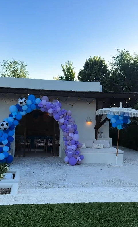 Entrada da área de festas da mansão de Cristiano Ronaldo e Georgina Rodríguez decorada com arcos de balões azuis e lilás para o aniversário dos gêmeos Eva e Matteo.