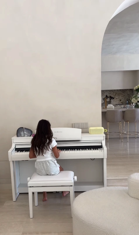 Filha de Cristiano Ronaldo e Georgina Rodríguez toca piano branco em um dos ambientes internos da mansão decorada em estilo minimalista.