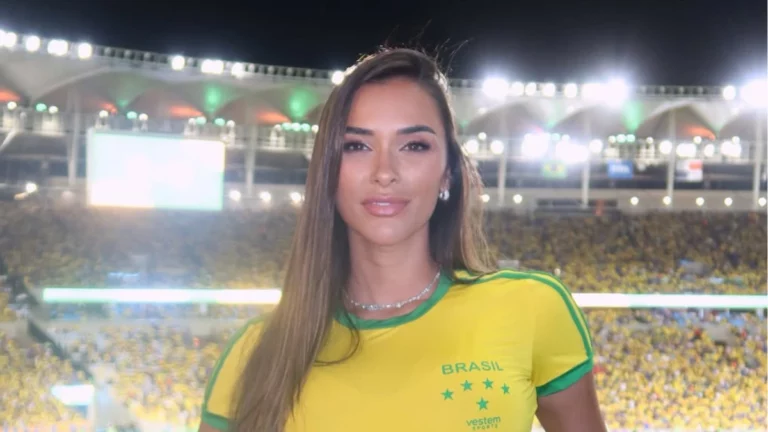 Tainá Militão relembra dificuldades em divórcio com Léo Pereira: ‘perdida’ Tainá Militão com camisa amarela da seleção brasileira posa em estádio iluminado durante evento esportivo noturno.