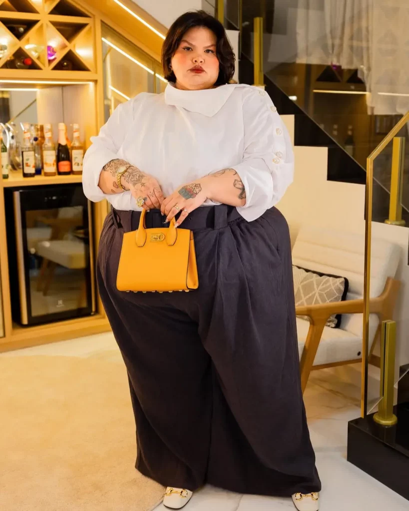 Thais Carla aparece em foto antes da bariátrica usando camisa branca e calça escura, em registro que integra a comparação de sua transformação física.
