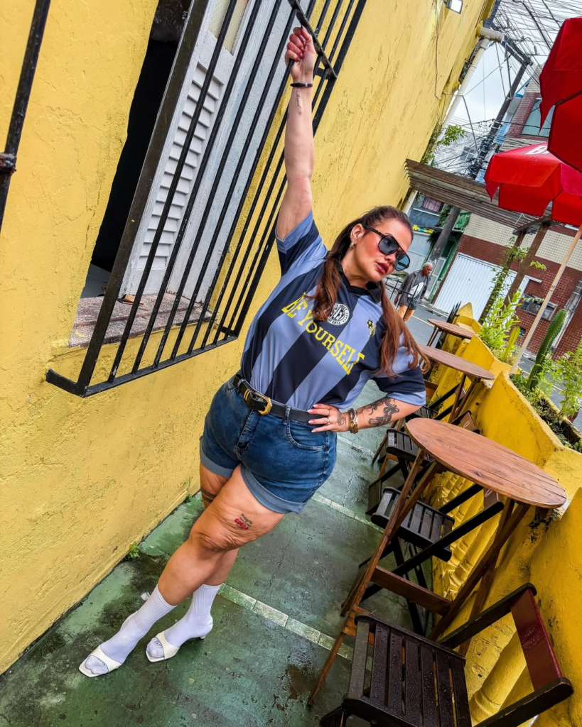 Thais Carla posa em área externa usando camisa esportiva e short jeans após a bariátrica, em registro recente da influenciadora após perder mais de 100 quilos.