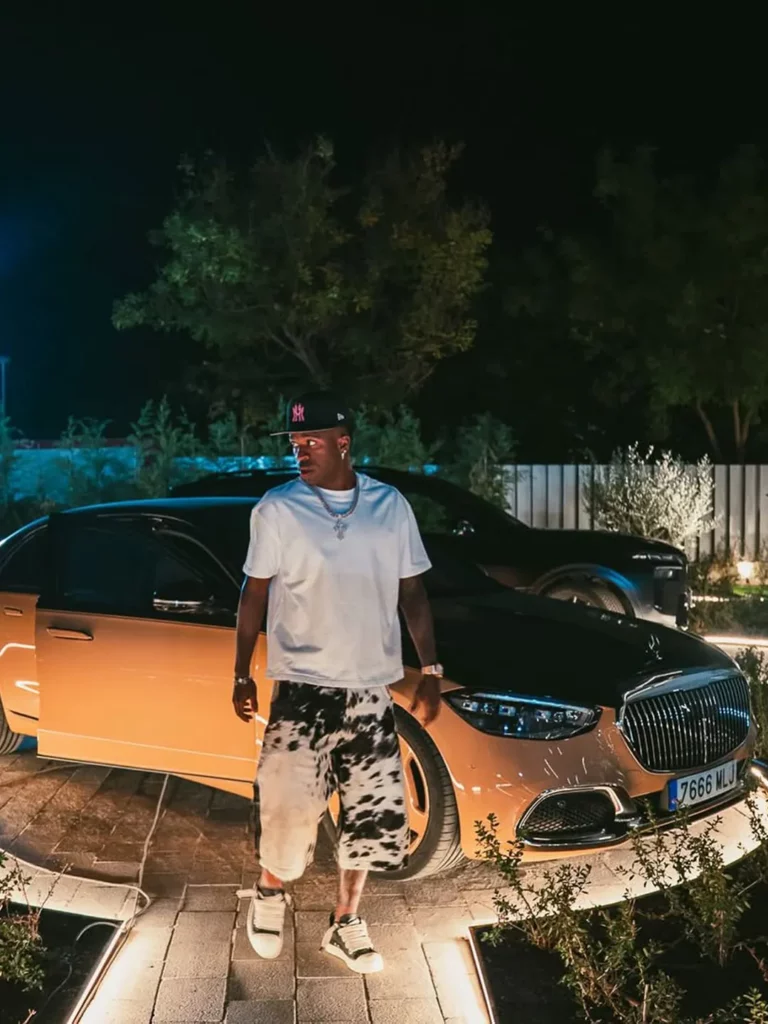 Fortuna de Vini Jr: patrimônio, salário e o bilhão da Arábia Saudita 2 Vini Jr posando com um carro de luxo