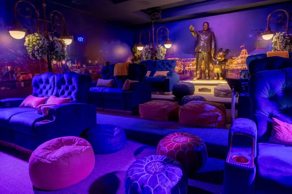 Virginia se hospeda em mansão de luxo em Orlando e valor impressiona; veja 3 Sala de cinema temática com poltronas reclináveis, pufes e decoração inspirada nos parques da Disney, incluindo estátuas de personagens icônicos.