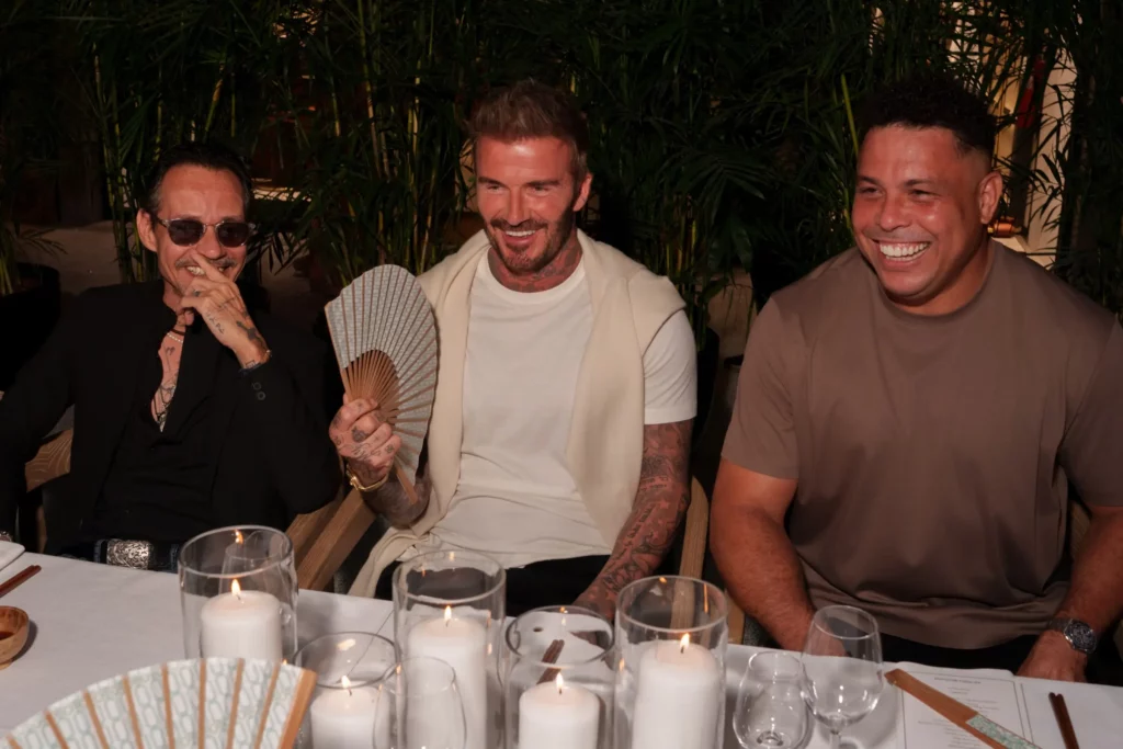 David Beckham aparece sorrindo ao lado de Ronaldo e outro convidado durante o jantar de inauguração da House of Victoria Beckham em Miami.