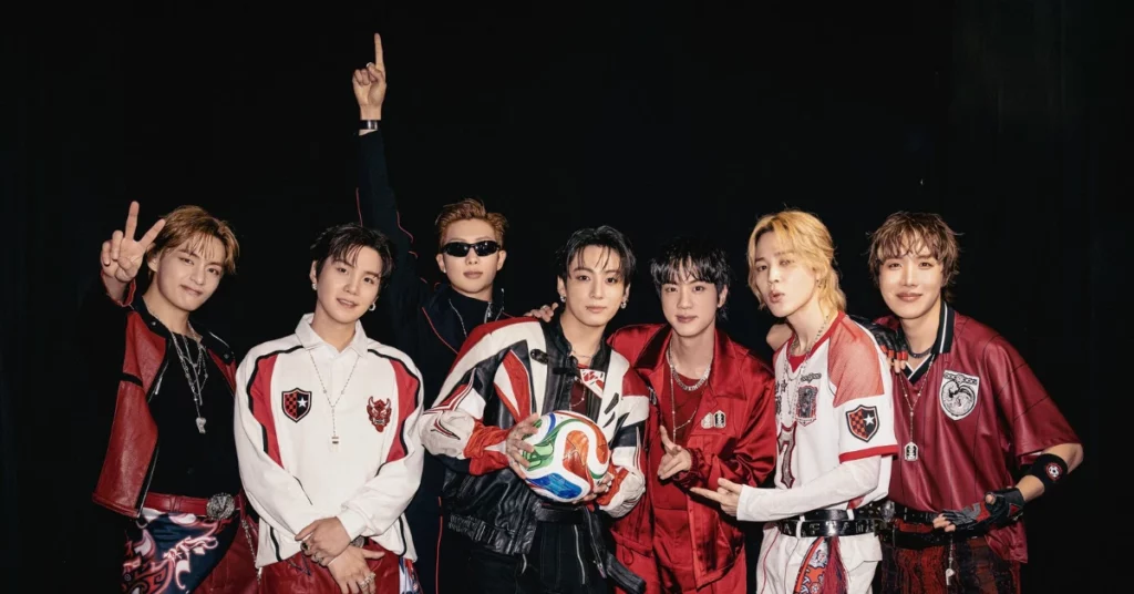 Sete integrantes do BTS posam juntos com figurinos em tons de vermelho, branco e preto