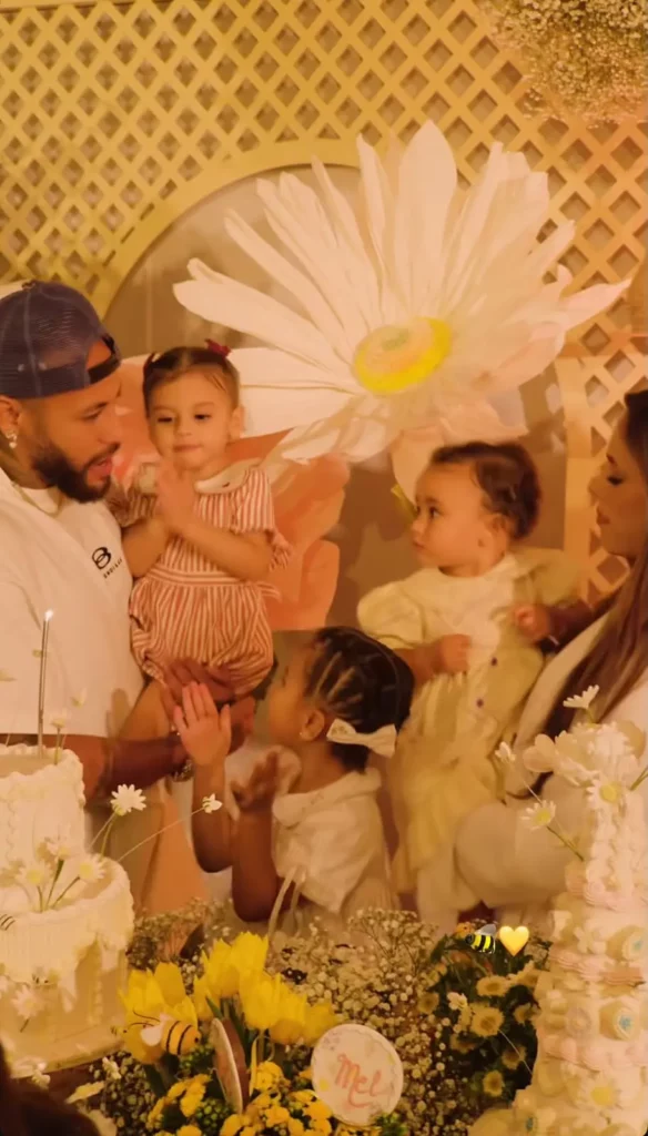 Momento do parabéns, com Neymar segurando Helena e Bruna segurando Mel. 