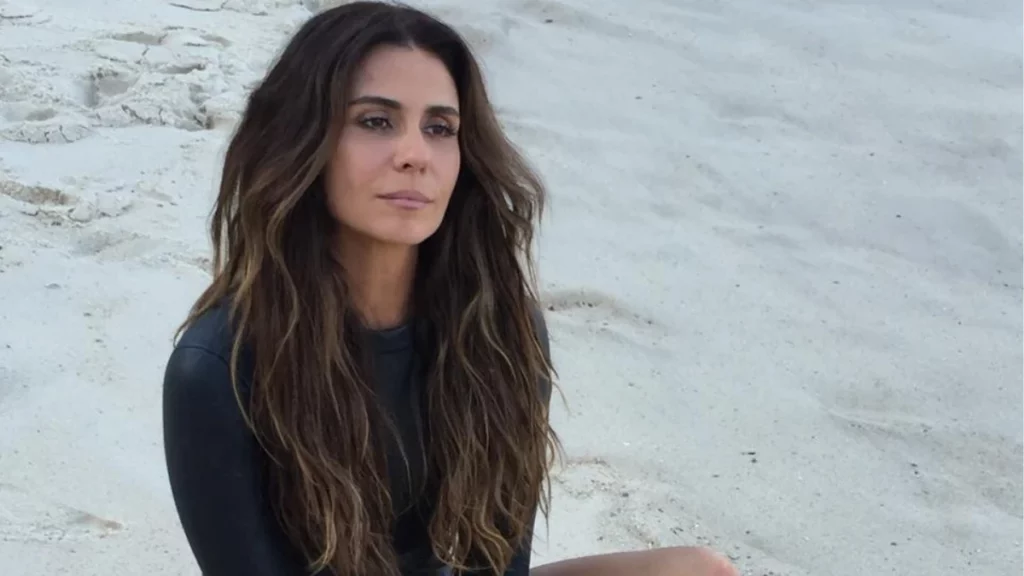 Giovanna Antonelli contesta cobrança de R$ 70 mil de IPTU e pede fim de ação na Justiça Giovanna Antonelli sentada na areia da praia usando roupa preta e olhando para o horizonte.