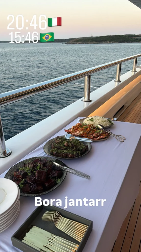 Mesa com pratos servidos em um barco de luxo durante comemoração na Itália.