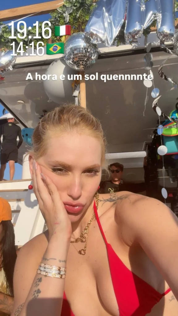 Virginia faz selfie usando biquíni vermelho durante festa em um barco na Itália.
