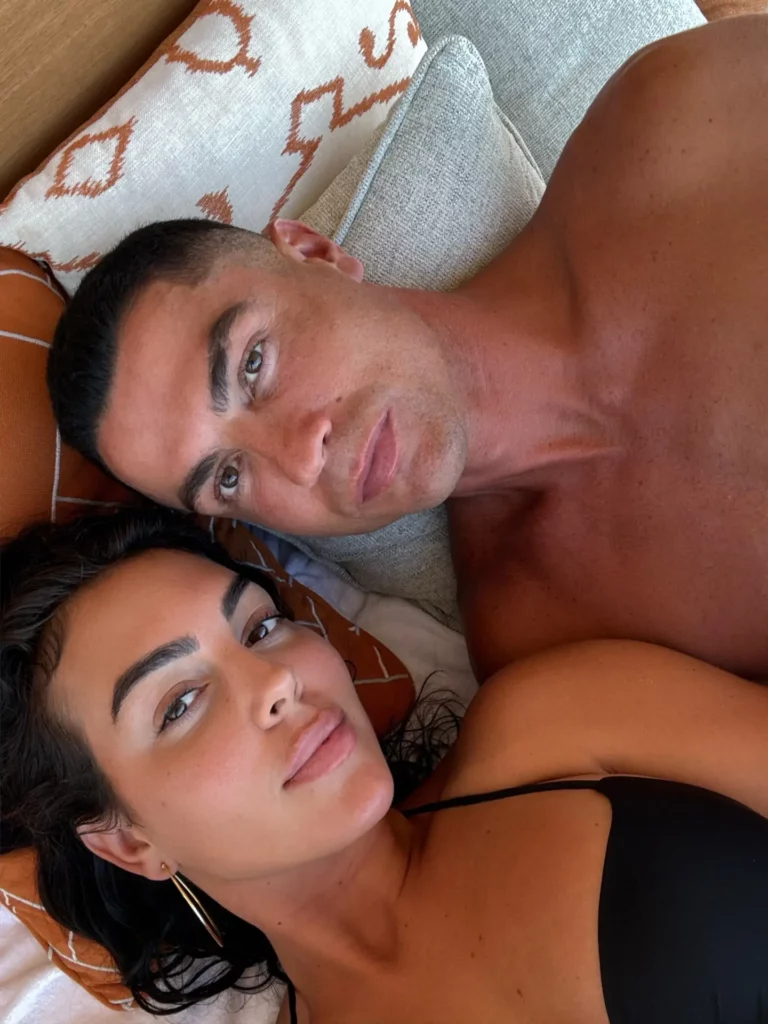 Close-up de Cristiano Ronaldo e Georgina Rodríguez deitados, olhando para a câmera.
