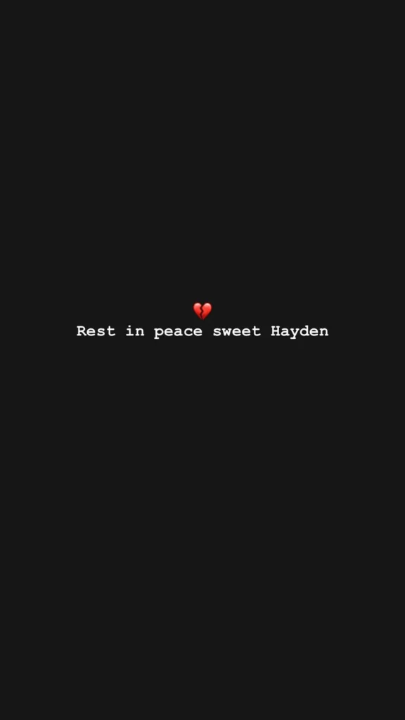 Captura de tela de um story do Instagram com fundo preto. No centro, há um emoji de coração partido acima do texto em branco: "Rest in peace sweet Hayden".