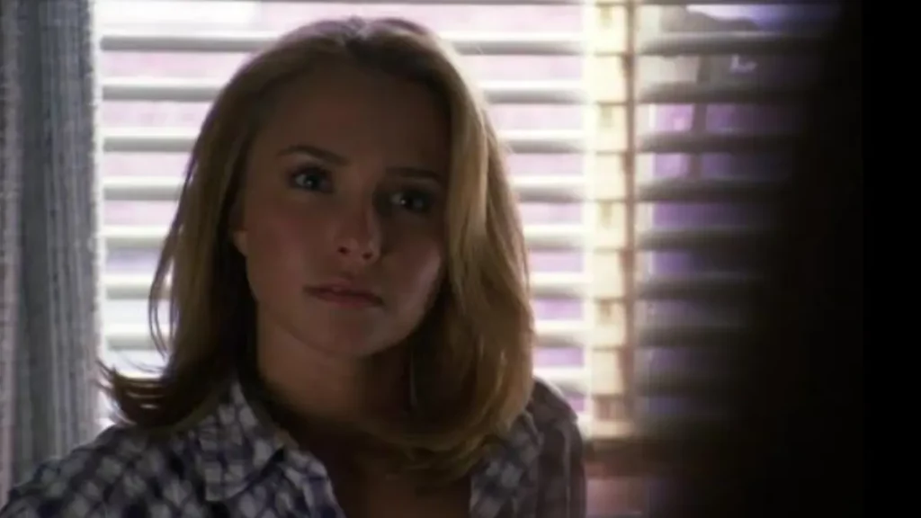 Hayden Panettiere aparece em cena de Heroes, usando camisa xadrez e com os cabelos soltos diante de uma janela.