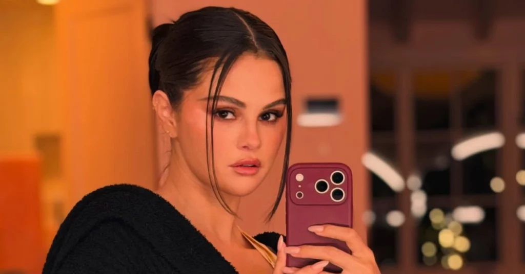 Selena Gomez tira selfie diante de um espelho segurando celular