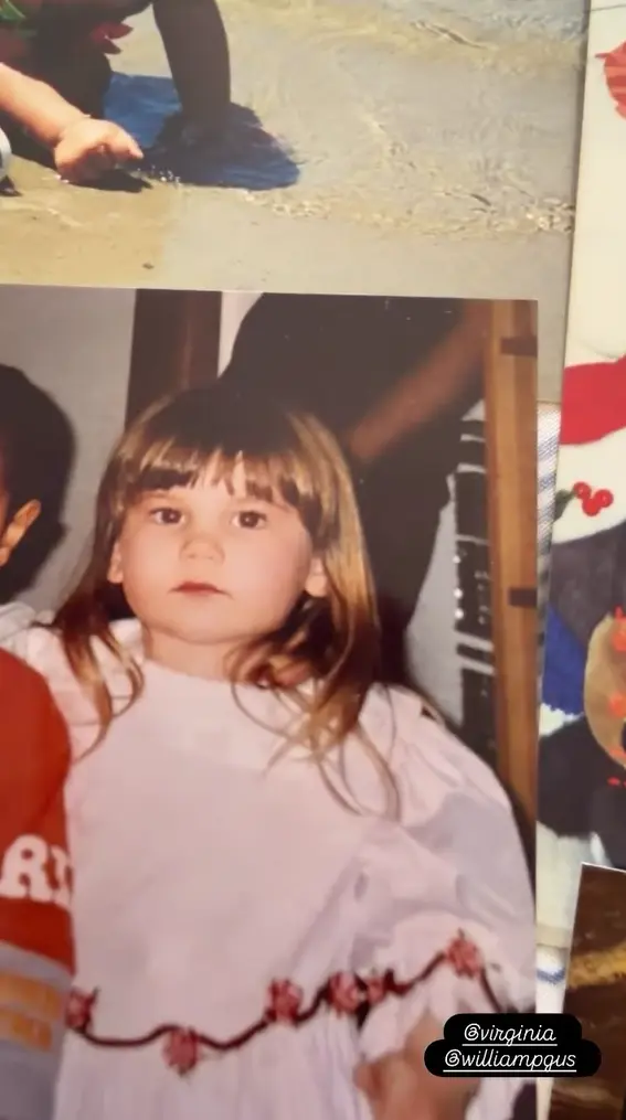 Virginia criança olhando para a câmera com expressão séria, vestindo um vestido lilás claro com babados.