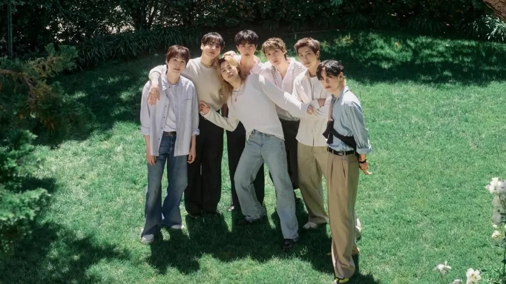 BTS faz história no VMA 2026 com três troféus e marca novo recorde BTS posa ao ar livre em um gramado em registro promocional do grupo.