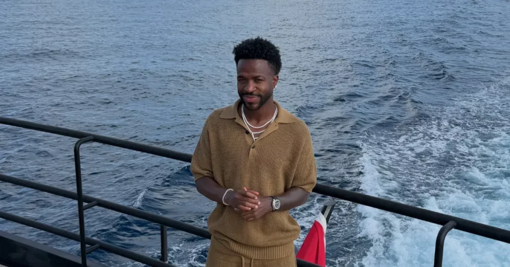 Vini Jr. processa influencer após suposta interação no Instagram; entenda Vini Jr. posa em embarcação diante do mar enquanto usa conjunto marrom e acessórios claros