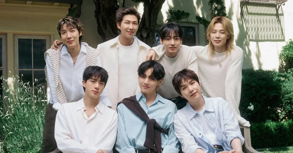 BTS no Brasil pode ter menos telões? Produtora quebra silêncio; confira Sete integrantes do BTS posam juntos ao ar livre, com roupas em tons claros e vegetação ao fundo