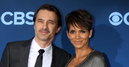Halle Berry e Olivier Martinez posam juntos em evento, diante de um painel azul, antes da disputa judicial pela guarda do filho Maceo